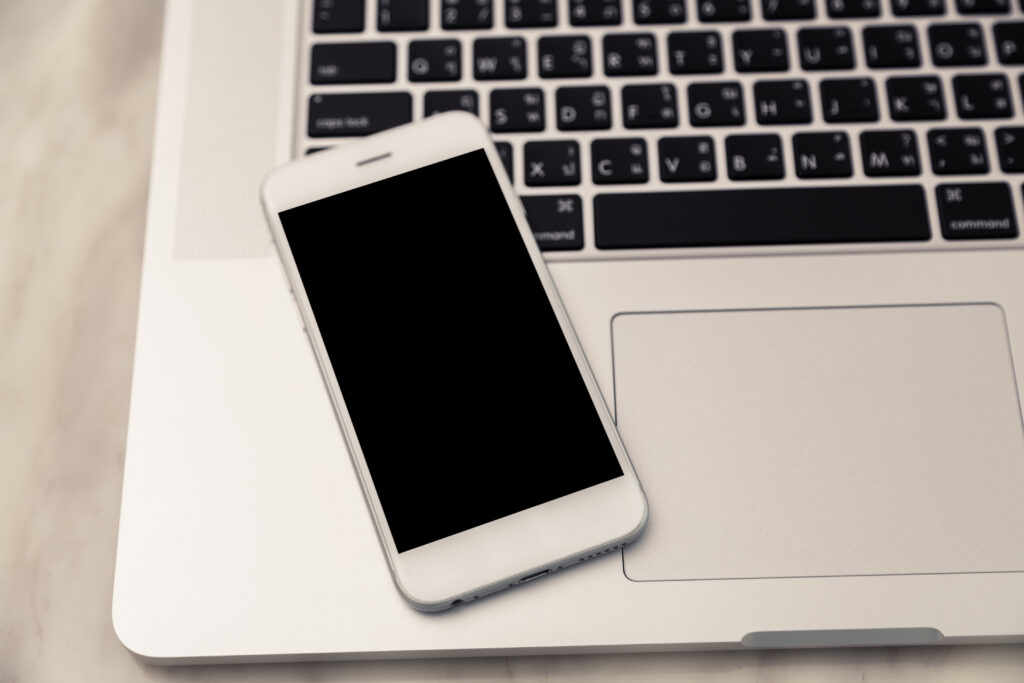 Laptop with smart phone on table